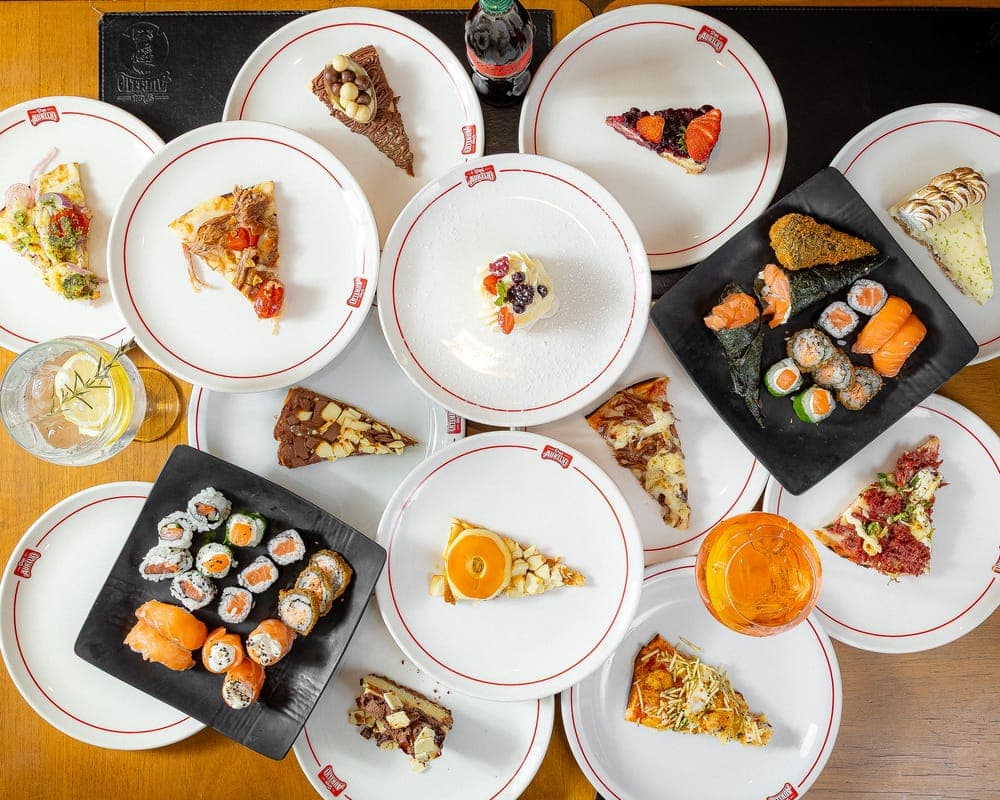 Mesa com pizzas, sushis e massas do rodízio